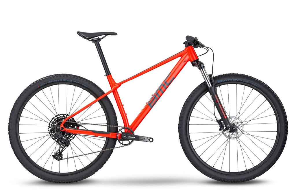 BMC Twostroke AL Four 2022 mountain bike with neon red and grey frame, front suspension, and rugged tires for off-road riding