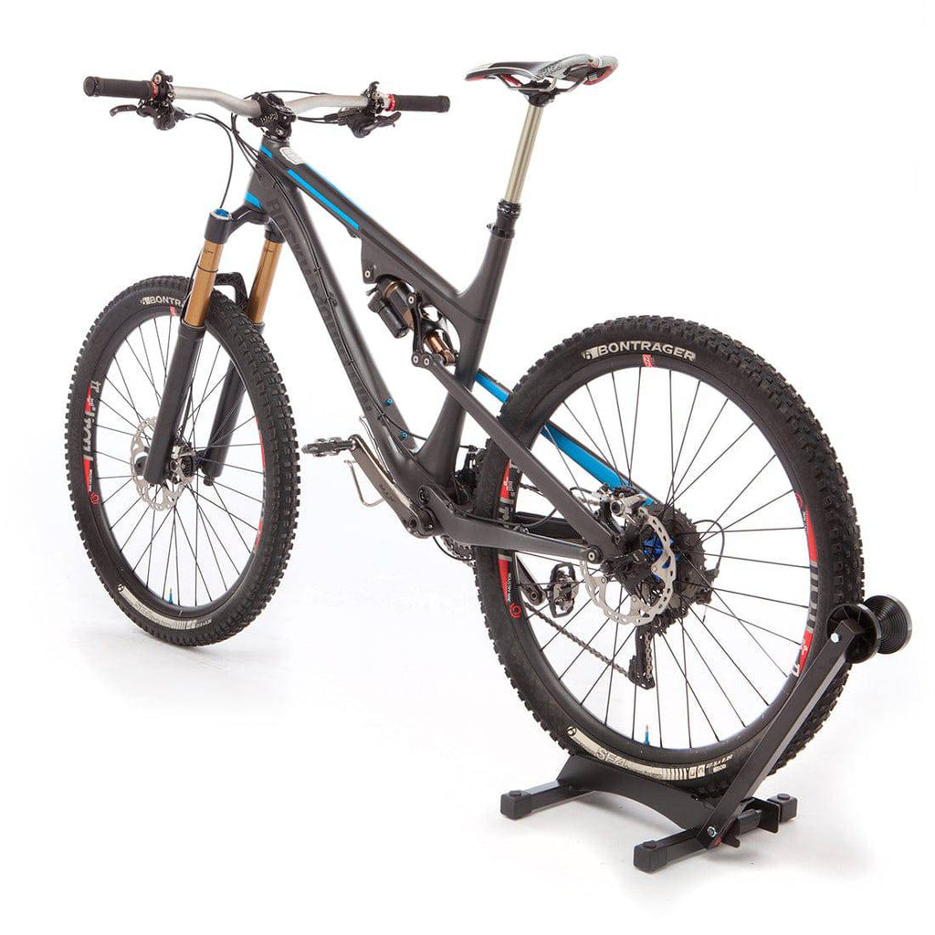 Black Feedback Sports RAKK bike display and storage stand holding a bicycle securely for storage or display.